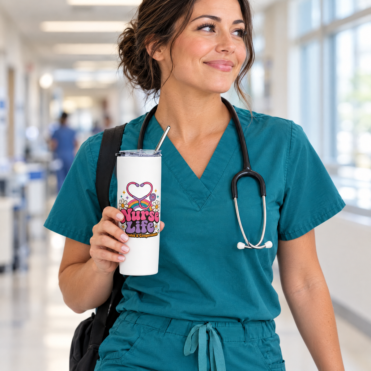 Nurse in teal scrubs walking a hospital hallway with the Nurse Life stainless steel straw tumbler