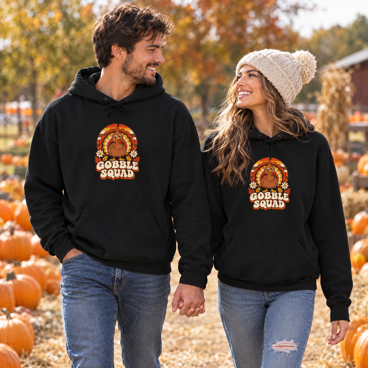Couple in matching black Gobble Squad hoodies walking through a pumpkin patch