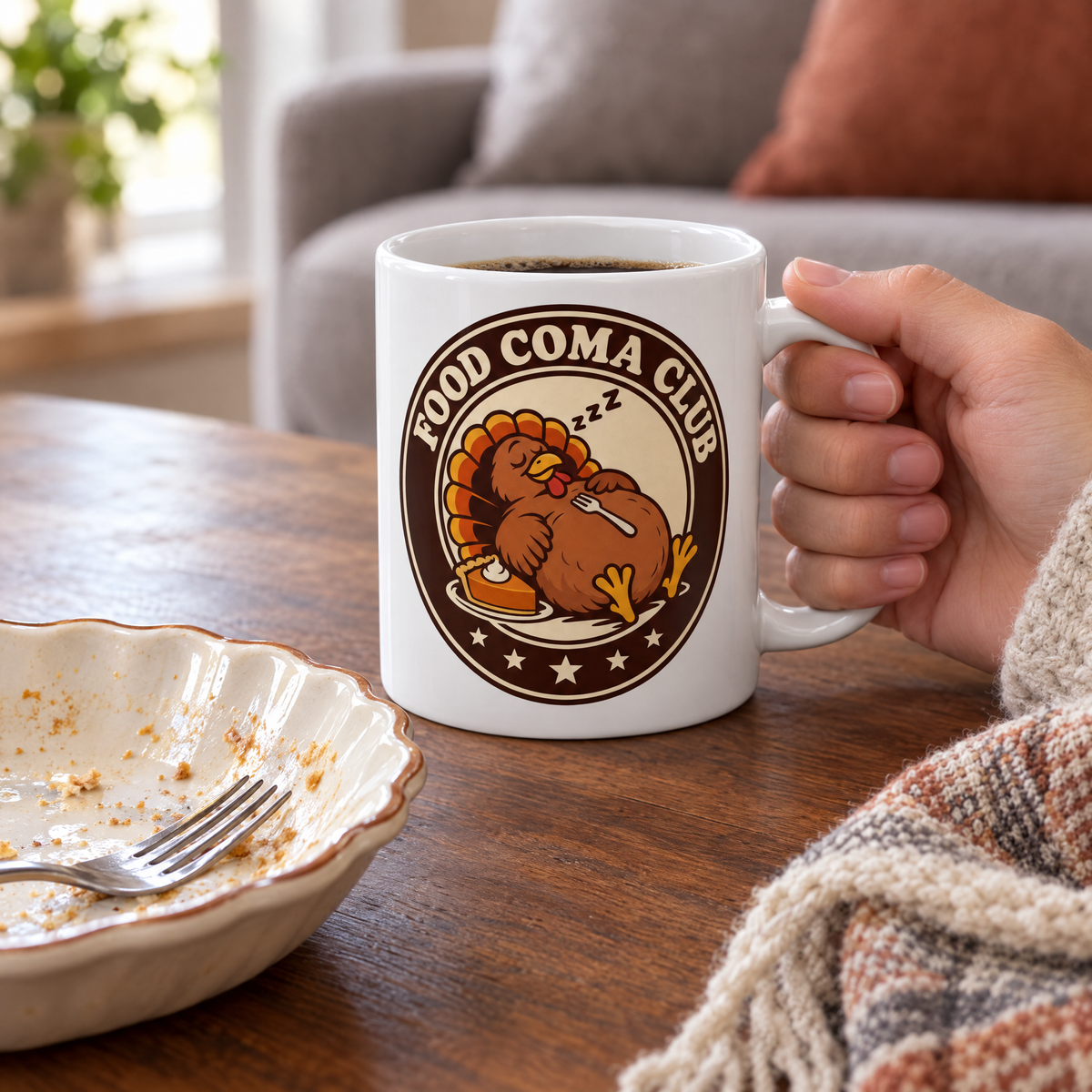 Food Coma Club sleepy turkey mug on a coffee table beside an empty pie plate
